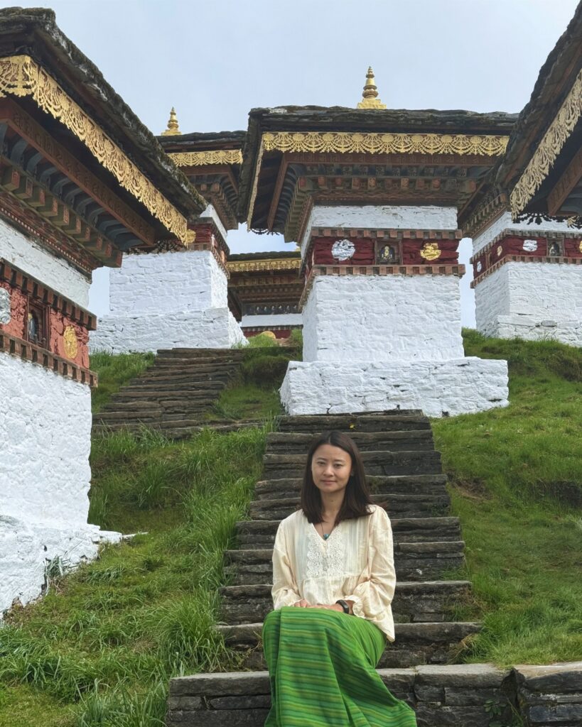 Meet Yangchen Yangchen among traditional Bhutanese architecture