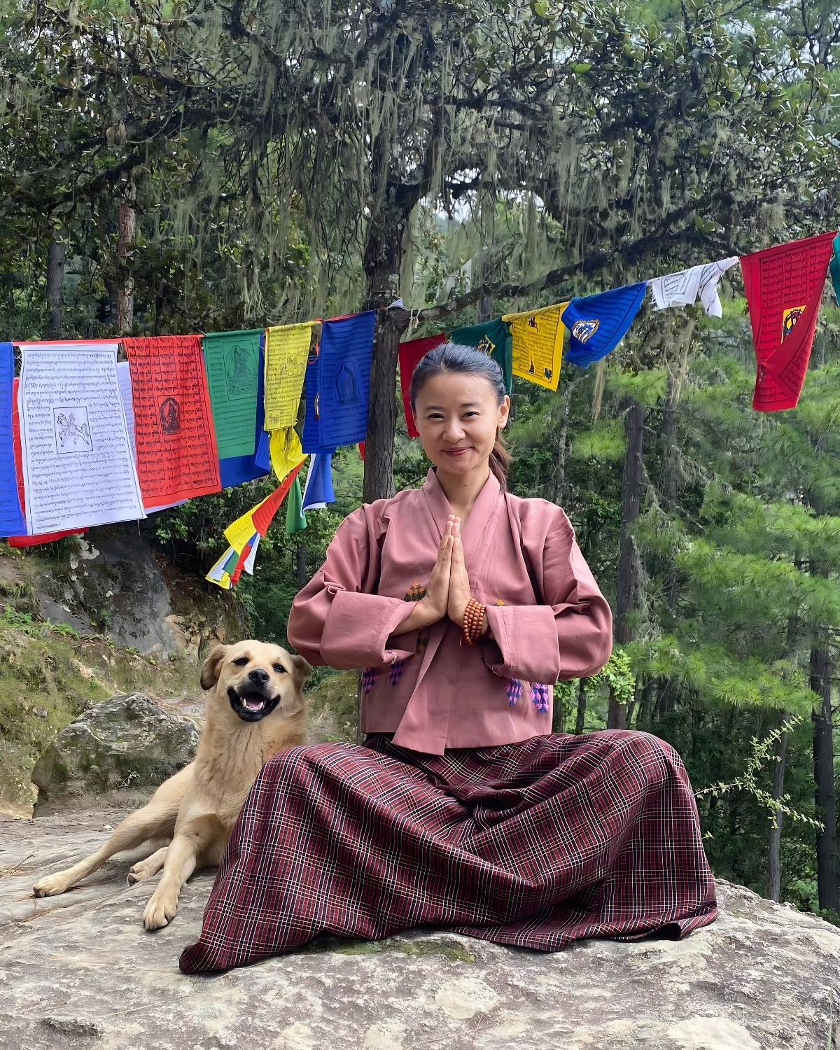 Yangchen sitting beside a dog in Bhutan