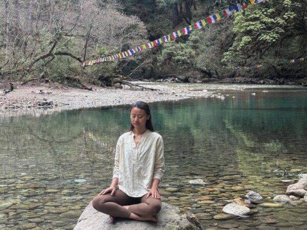 Mindfulness in nature Yangchen meditating beside a river in Bhutan