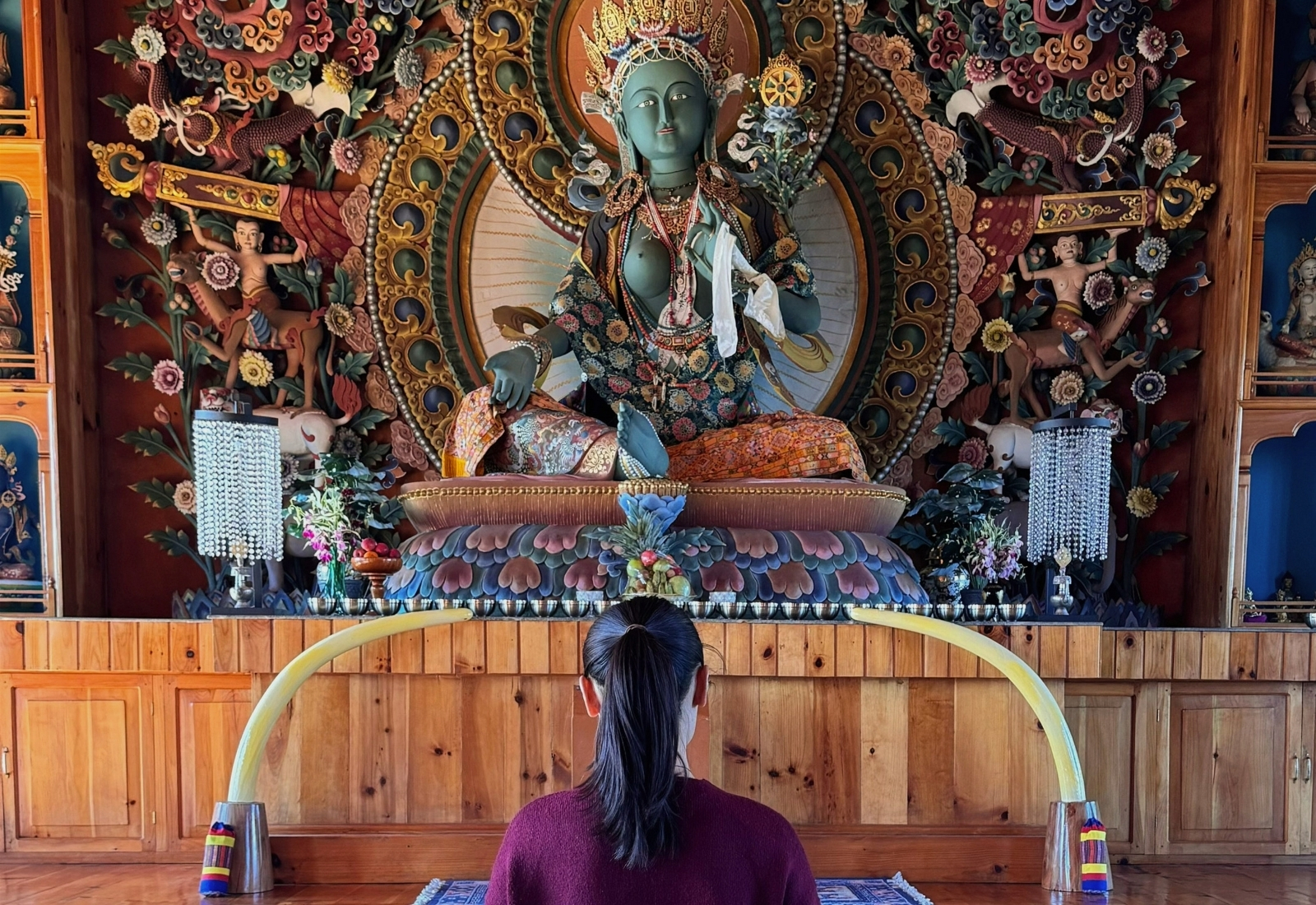 Yangchen seated before a Buddhist shrine in Bhutan